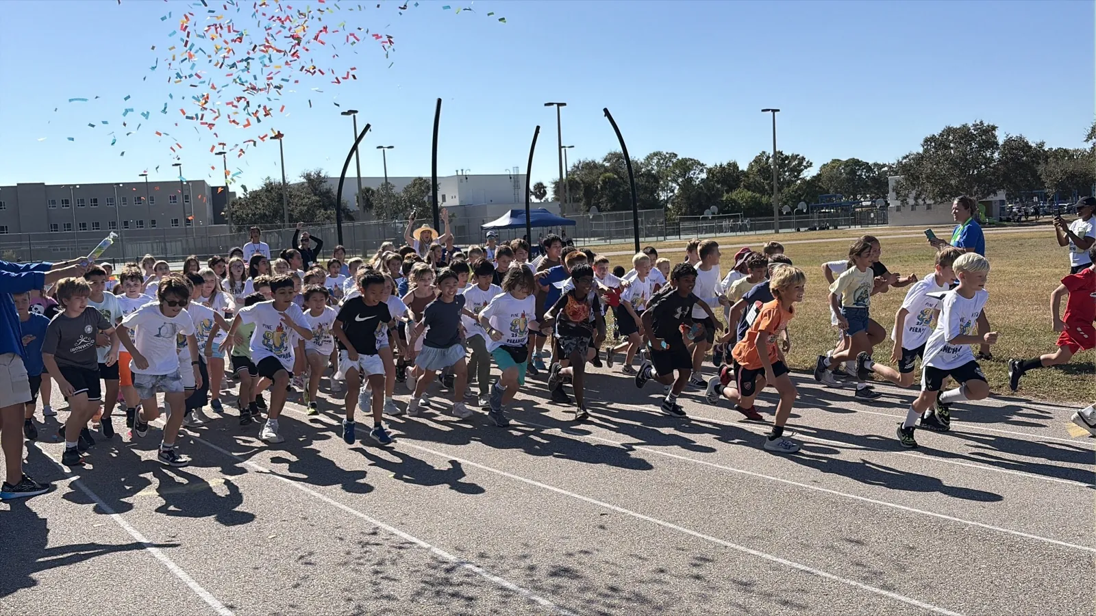 Students running, grade-level competitions, volunteers, cheering