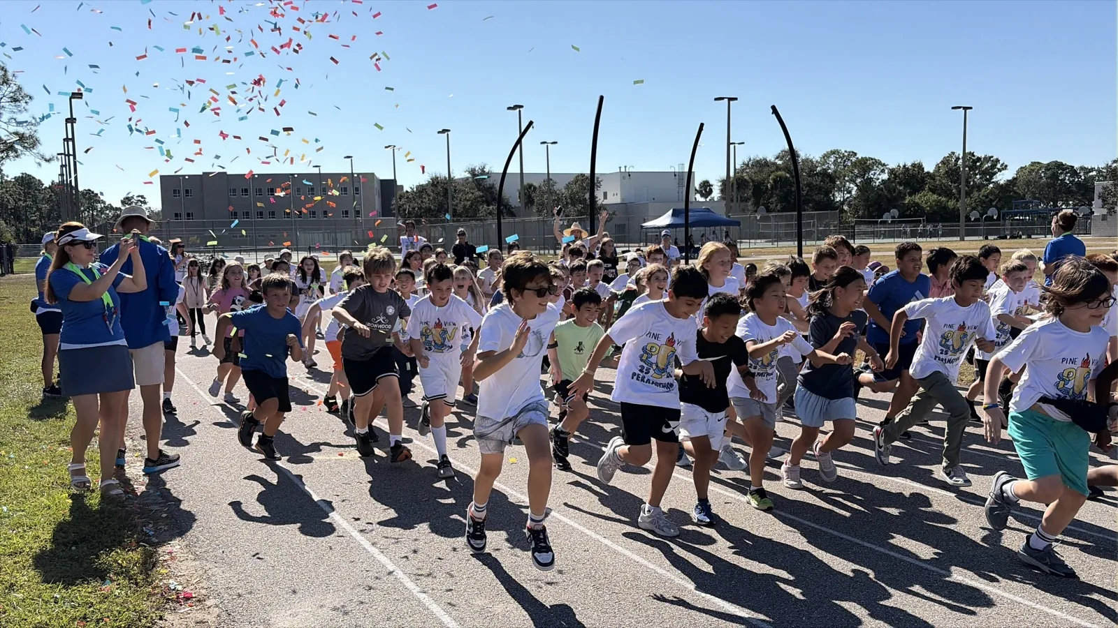 Students running, grade-level competitions, volunteers, cheering
