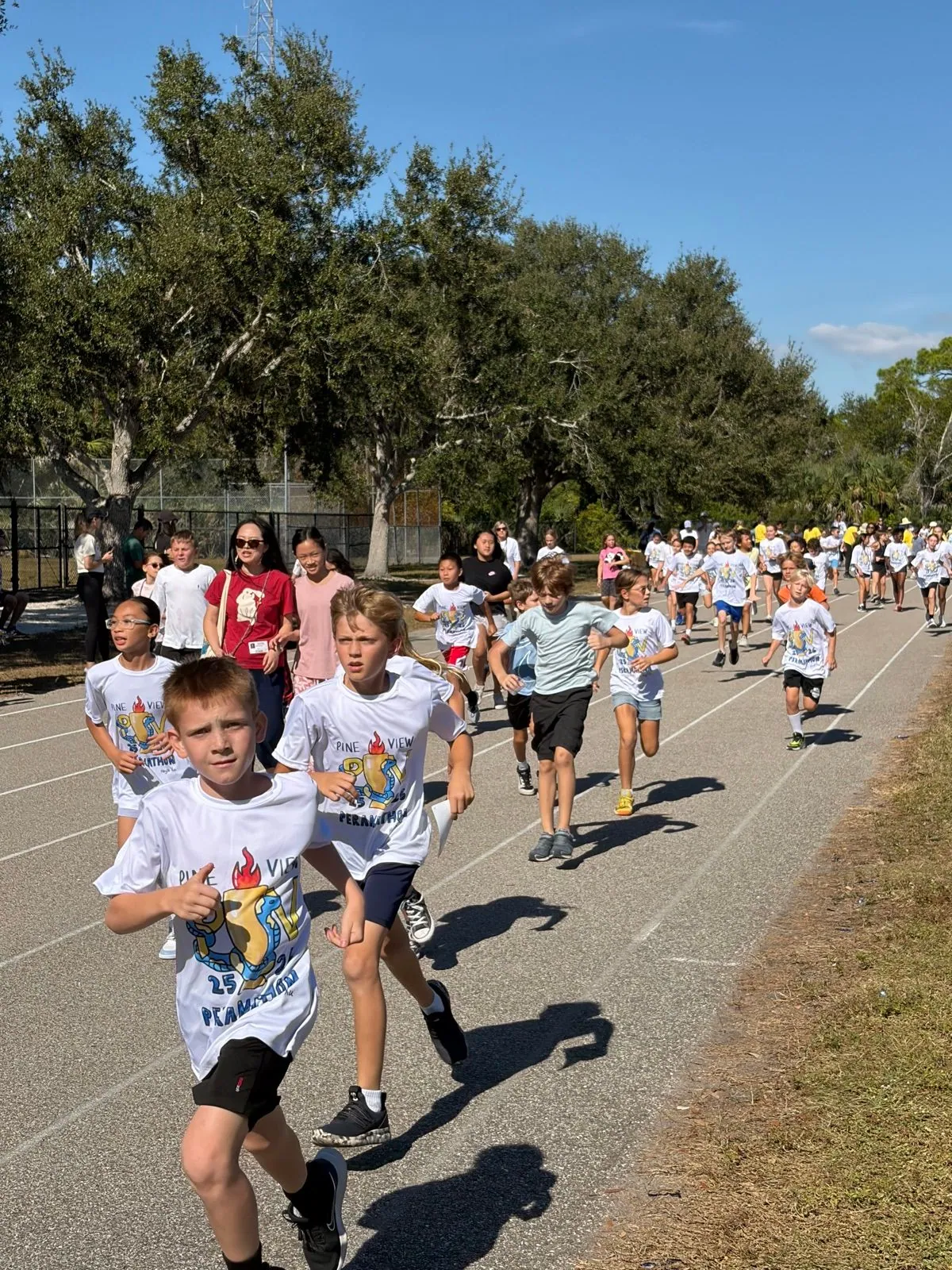 Students running, grade-level competitions, volunteers, cheering